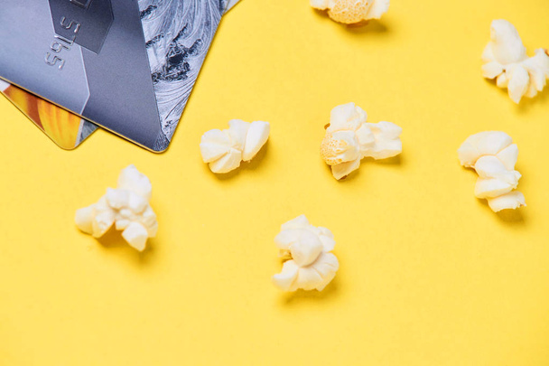 Fresh white popcorn. Plastic card. Yellow background - Φωτογραφία, εικόνα