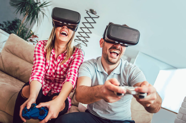 Gelukkige vrienden spelen video games met virtual reality bril - Foto, afbeelding