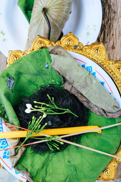 Haren op het blad van lotus, ceremonie van haar scheren, boeddhistische wijding - Foto, afbeelding