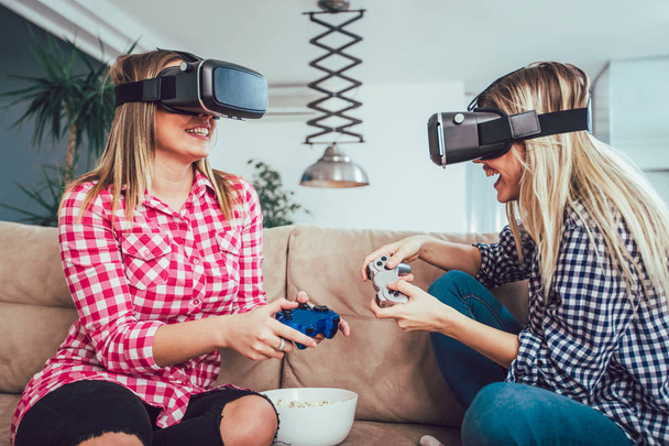 仮想現実のメガネでビデオゲームをプレイする幸せな友人-新しい技術コンソールをオンラインで楽しんでいる若者 - 写真・画像