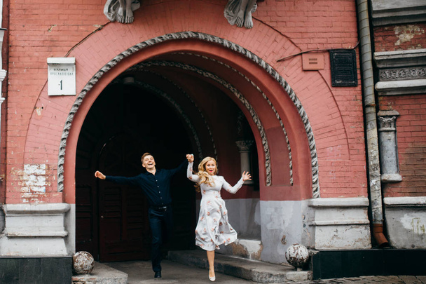 young beautiful couple jumping  in city  - 写真・画像