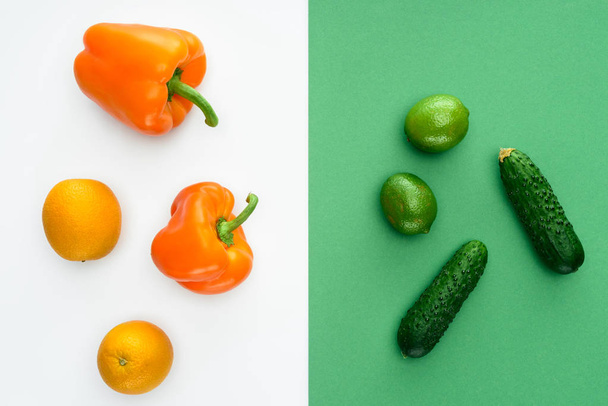 top view of orange and green fruits and vegetables on white and green surface - 写真・画像
