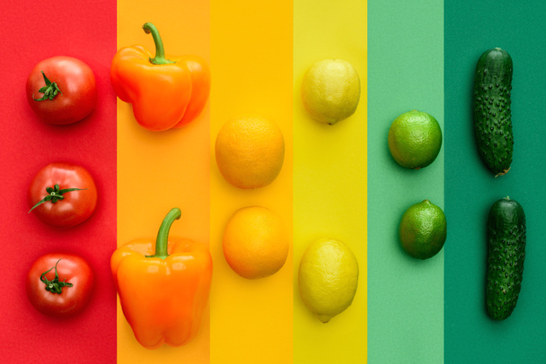 вид зверху на стиглий болгарський перець, апельсини та вапняки на кольоровій поверхні
 - Фото, зображення
