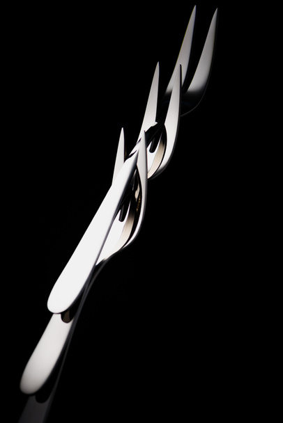 Фруктовые вилки с двумя зубцами, изолированными на черном
 - Фото, изображение