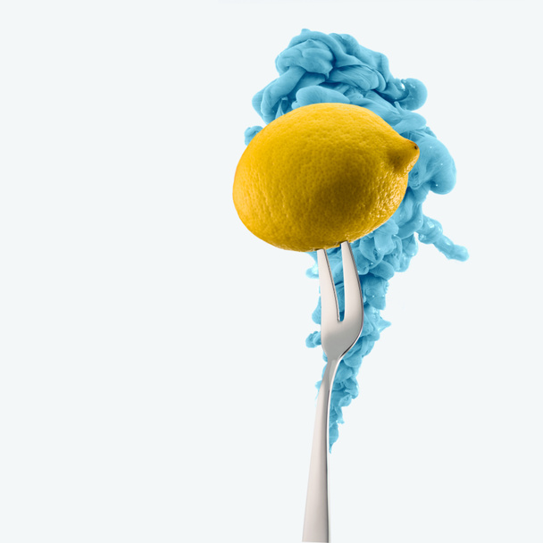 lemon on fork and blue ink isolated on white - Photo, Image