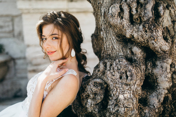 young  beautiful  bride posing by tree - Foto, afbeelding