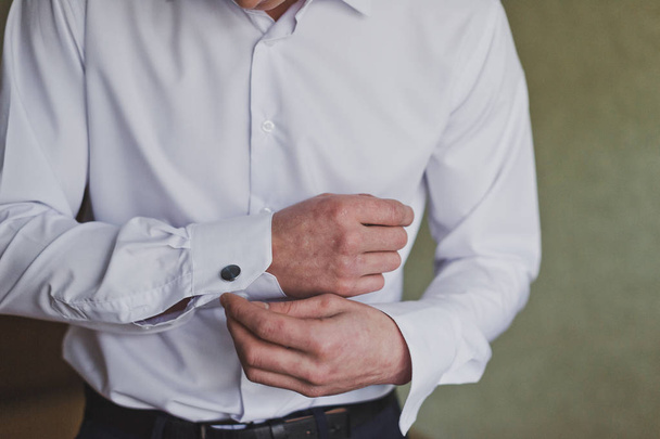 The process of buttoning a white shirt sleeve by a man 1181. - Foto, imagen