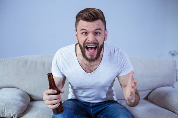 man with bottle of beer watching football  - Photo, Image
