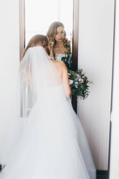 young  beautiful  bride looking in mirror - Photo, image