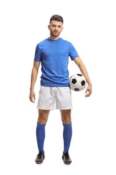 Full length portrait of a soccer player holding a football and looking at the camera isolated on white background - Foto, immagini