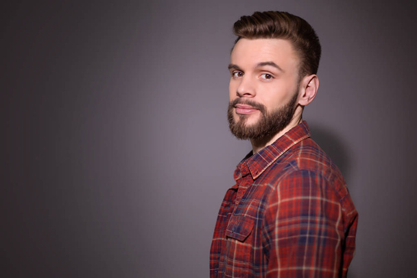 young handsome man posing in studio wearing red plaid shirt  - Photo, image