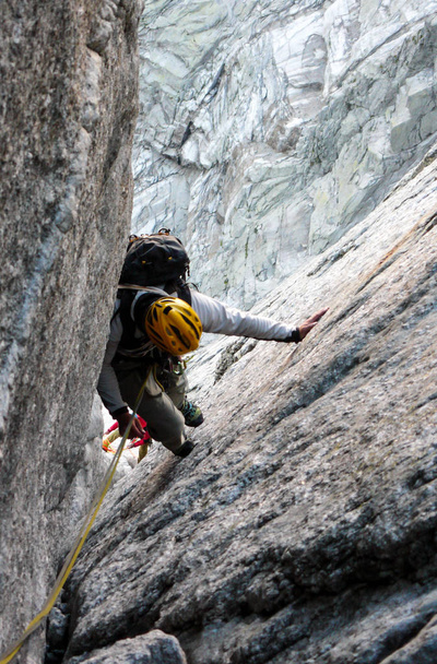 horského vůdce na tvrdé žuly vylézt na vysoký vrch tyčící ve švýcarských Alpách - Fotografie, Obrázek