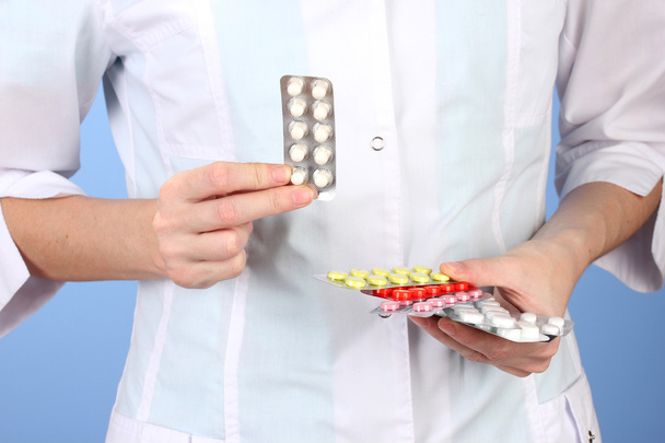 Primer plano de las píldoras de la mano del médico femenino, sobre fondo de color
 - Foto, imagen