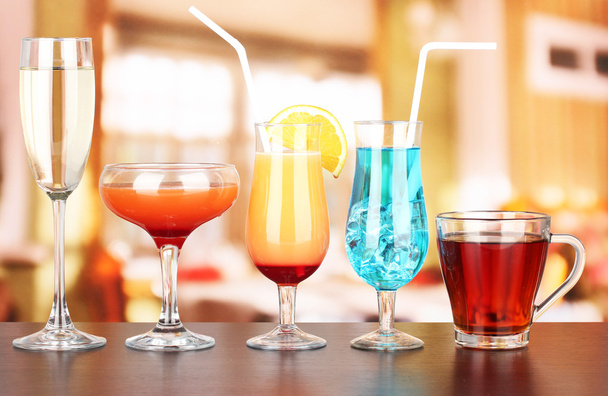 Several glasses of different drinks on bright background - Foto, immagini