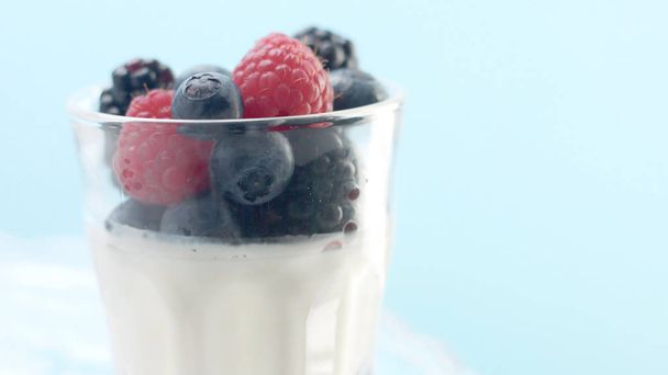 Przezroczyste szklanki pełne jogurtu, Panna Cotta, mus waniliowy biały ozdobiony jagodami - Zdjęcie, obraz