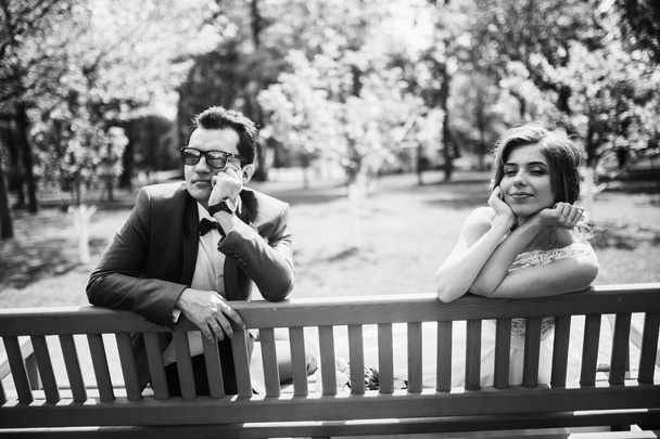 beautiful  couple of newlyweds posing on bench - Fotoğraf, Görsel