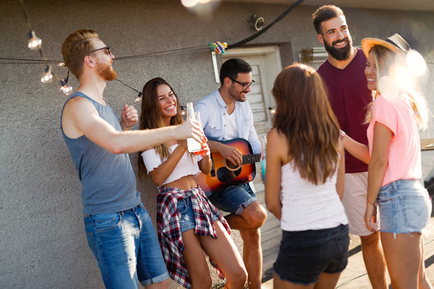 Group of happy smiling friends having party on rooftop - Photo, image