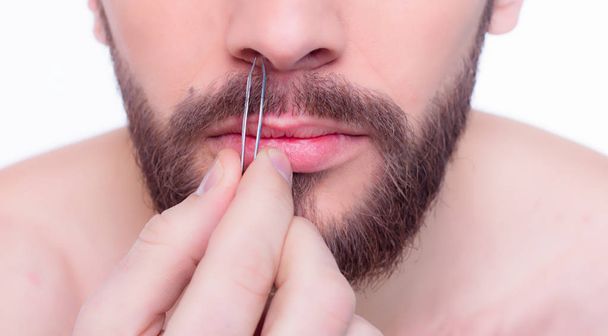 man pluck out hair in his nose with  tweezers - Фото, зображення
