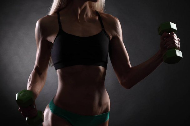 молода спортивна тонка м'язова дівчина з гантелями
 - Фото, зображення