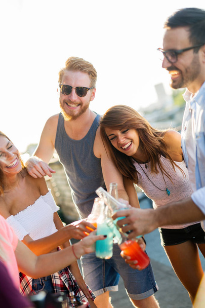 Friends having fun and drinking cocktails outdoor on a rooftop get together - 写真・画像