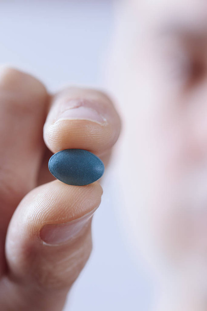 молодий чоловік з блакитною таблеткою
 - Фото, зображення