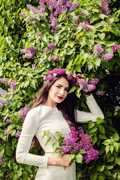 Весела молода жінка з макіяжем і весняними бузковими квітами
  - Фото, зображення