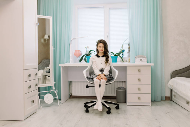 Красивая девушка в своей комнате стоит рядом со столом
 - Фото, изображение