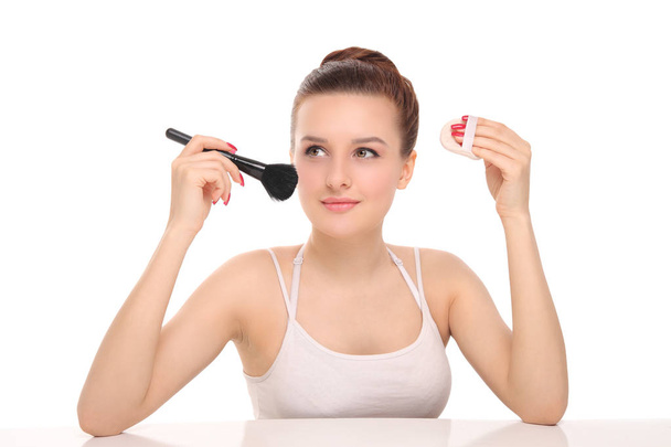 woman applying dry cosmetic powder - Foto, afbeelding