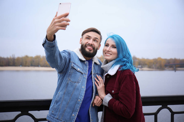 Young hipster couple taking selfie outdoors - Foto, afbeelding