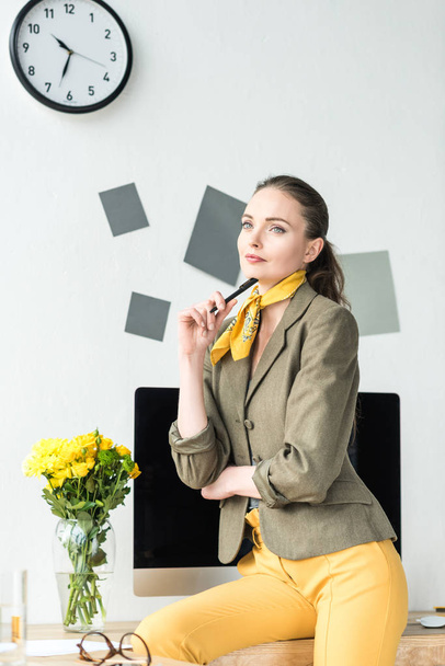 portrét zamyšlený podnikatelka s perem na pracovišti s obrazovkou počítače v kanceláři - Fotografie, Obrázek