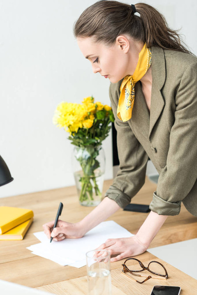 attractive stylish businesswoman taking notes at workplace - 写真・画像