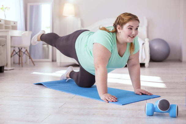 Smiling red-head woman doing exercises - Photo, image