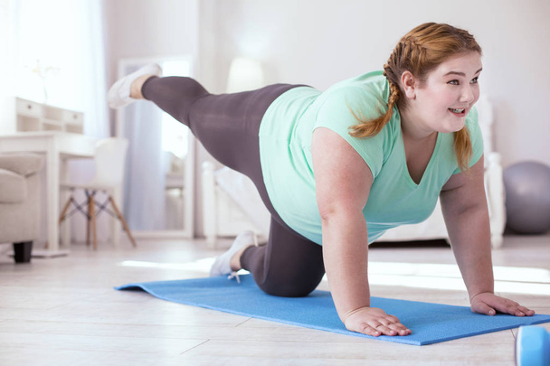Plump young woman doing last move in the exercise - Photo, image