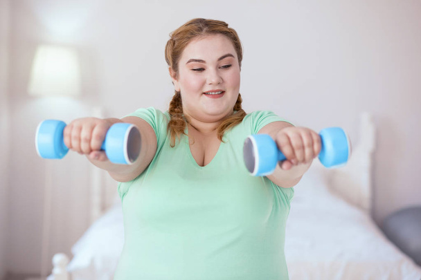 Obese young woman holding dumbbells - Fotografie, Obrázek