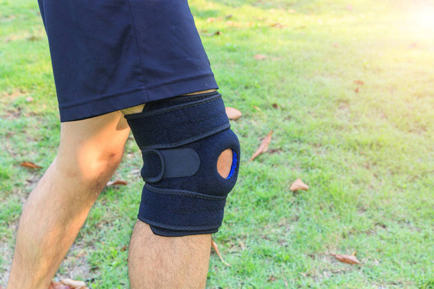 The man wear Knee Support with sunlight in the park / Brace Knee Pads Leg  - Фото, изображение