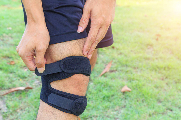The man wear Knee Support with sunlight in the park / Brace Knee Pads Leg  - 写真・画像