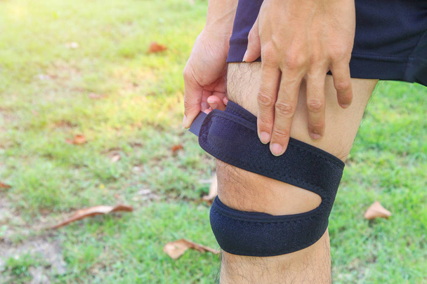 The man wear Knee Support with sunlight in the park / Brace Knee Pads Leg  - Foto, immagini