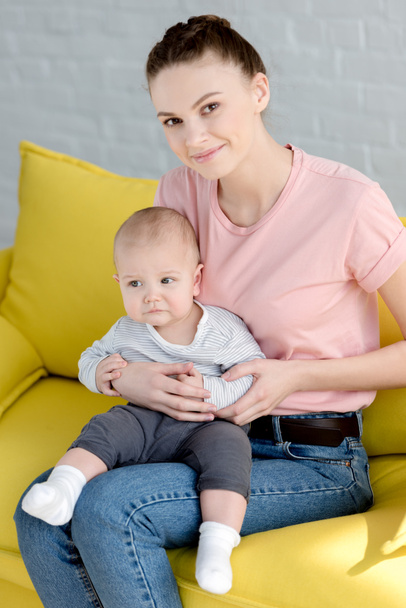 young mother with little son sitting on sofa - Φωτογραφία, εικόνα