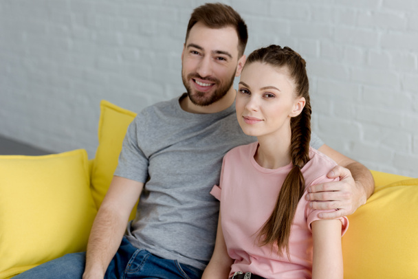 happy couple hugging and sitting on sofa  - Foto, imagen