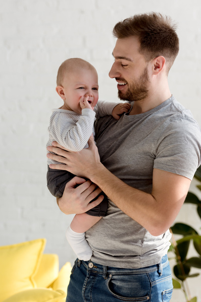 smiling father holding little son at home  - Фото, изображение