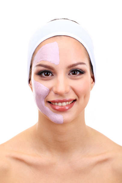 jonge vrouw met klei gezichtsmasker, geïsoleerd op wit - Foto, afbeelding