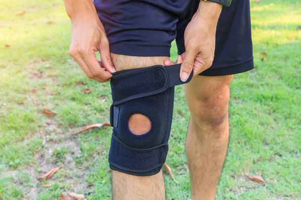 The man wear Knee Support with sunlight in the park / Brace Knee Pads Leg  - Foto, Imagem