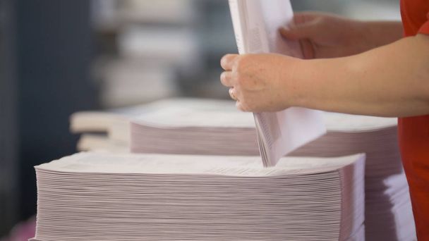 Hands of female workers shift the paper stacks - Photo, Image