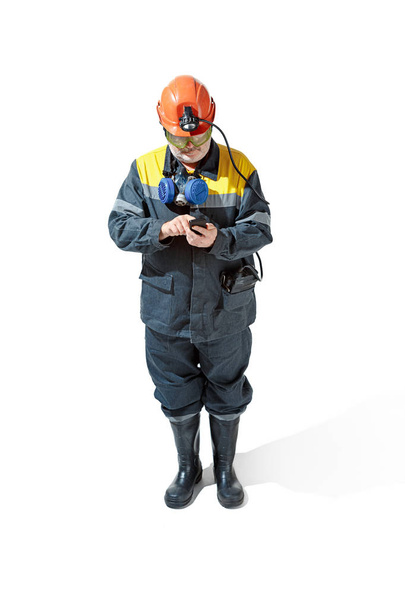 The studio shot of senior bearded male miner standing at the camera on a white background. - Foto, Imagen