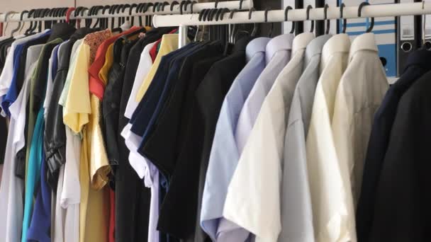 moderner Laden mit Kleiderbügeln voller unterschiedlicher Kleidung - Filmmaterial, Video