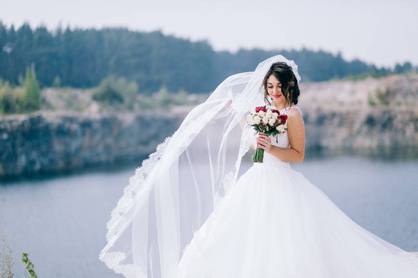 young  beautiful  bride posing with bouquet  - Photo, image