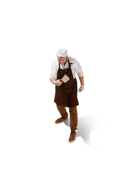 Angry aggressive butcher posing with a cleaver isolated on white background - Valokuva, kuva