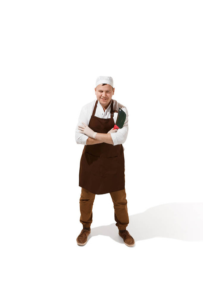 Smiling butcher posing with a cleaver isolated on white background - Fotoğraf, Görsel