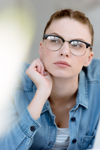 Porträt einer nachdenklichen jungen Frau mit Brille  - Foto, Bild