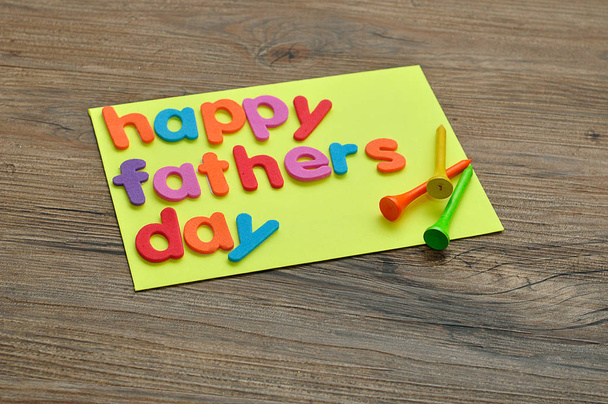 A note with the word happy fathers day and golf tees - Zdjęcie, obraz